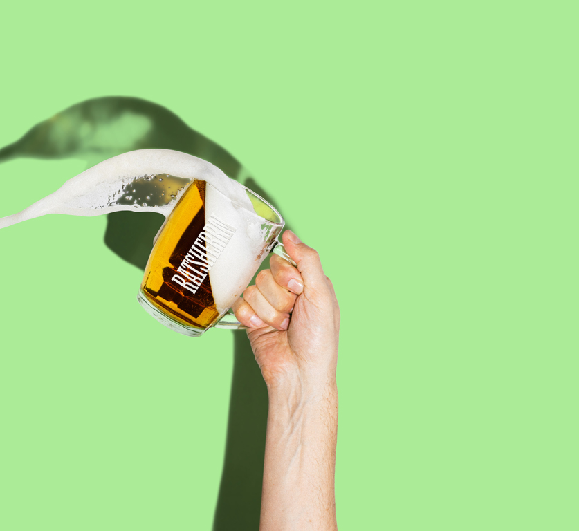 Hand schwenkt Bierglas, Bier kippt aus dem Glas heraus